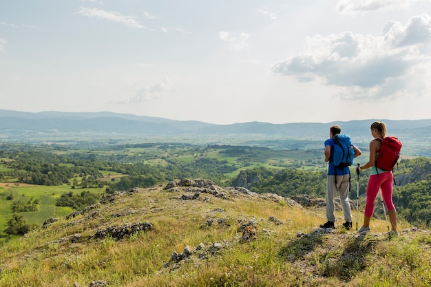 Junge Paare, die auf dem Berg wandern