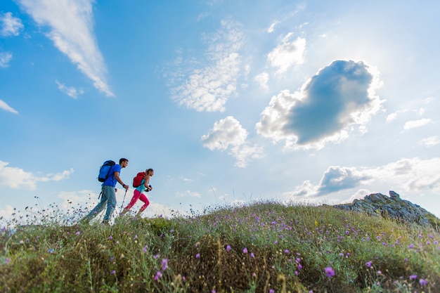 Junge Paare, die auf dem Berg wandern