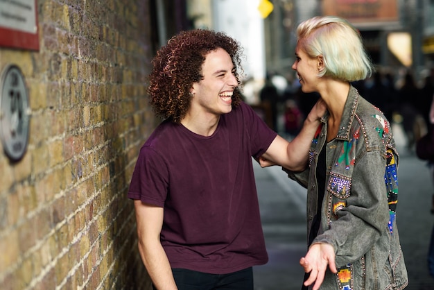 Junge Paare, die im städtischen Hintergrund auf einer typischen London-Straße sprechen.