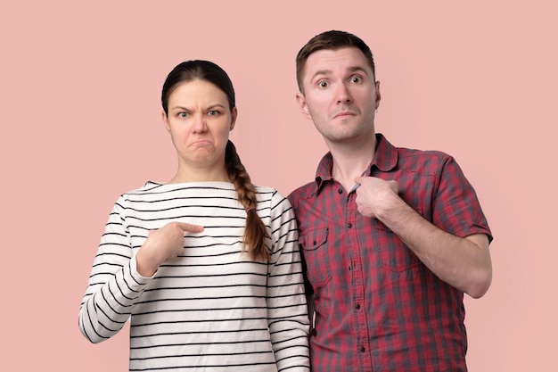 Foto junge paare, die mit dem finger zeigen und zweifelhafte emotionen haben