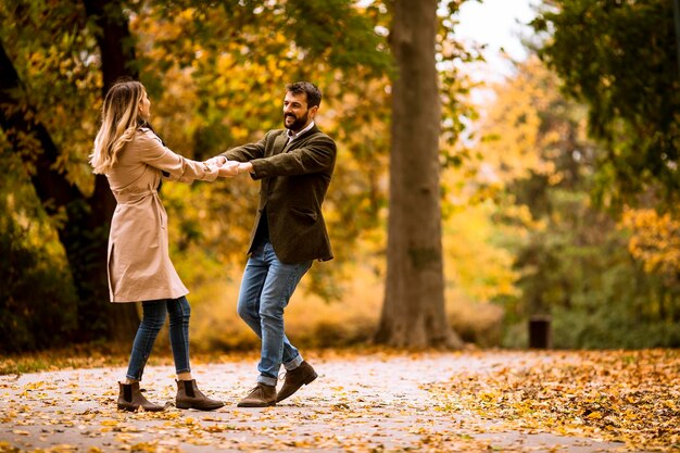 Junge Paare, die Spaß im Herbstpark haben