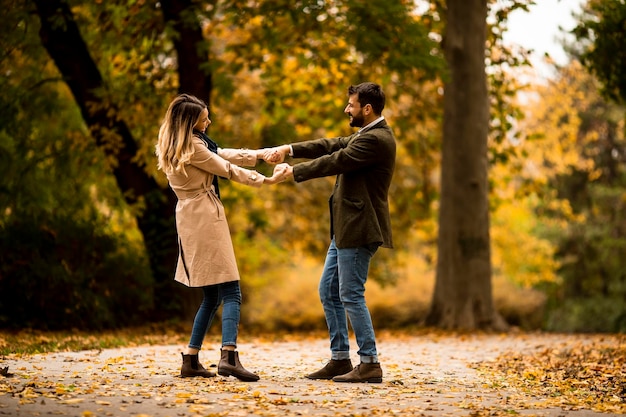 Junge Paare, die Spaß im Herbstpark haben