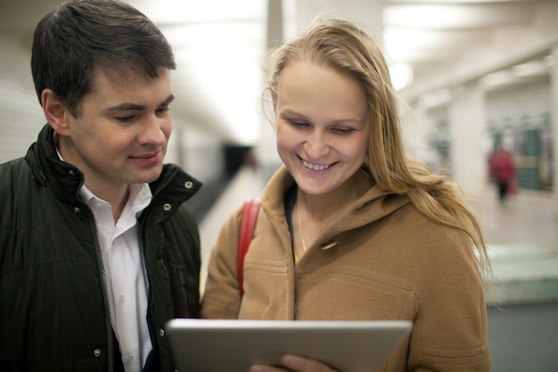 Junge Paare, die Tablet-Computer im Untertag verwenden