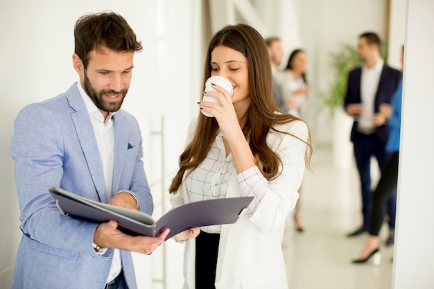 Junge Paare, die über Geschäft im modernen Büro sich besprechen