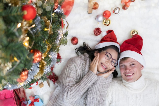 Junge Paare, die zu Hause für Weihnachts- oder Neujahrszeit genießen.