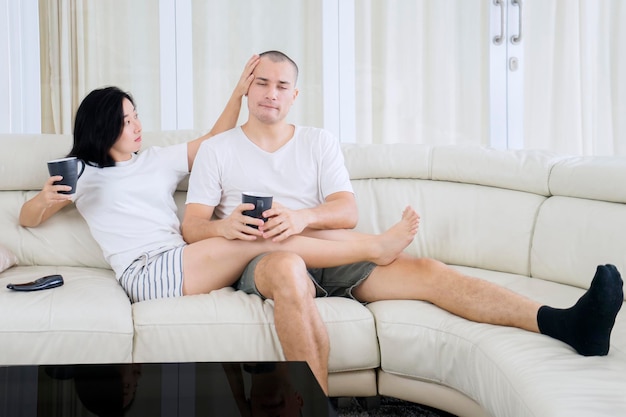 Junge Paare, die zusammen auf der Couch plaudern