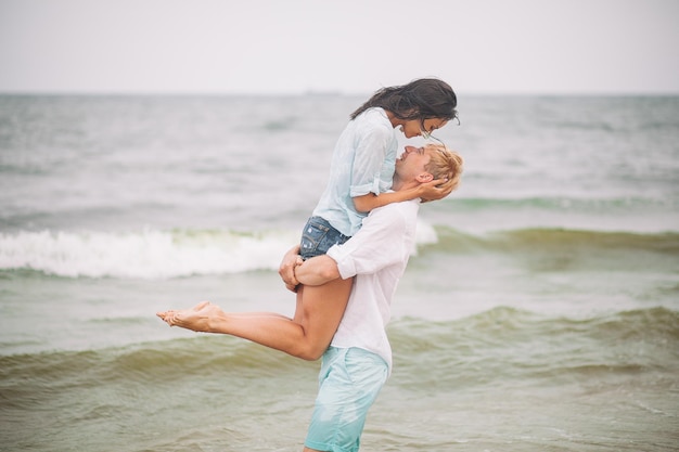 Junge Paare haben Spaß am Sommertag am Strand