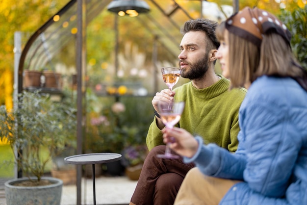 Junge Paare haben Spaß und trinken Wein im Hinterhof