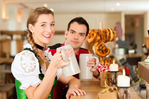 Junge Paare in der traditionellen bayerischen Tracht im Restaurant oder in der Kneipe