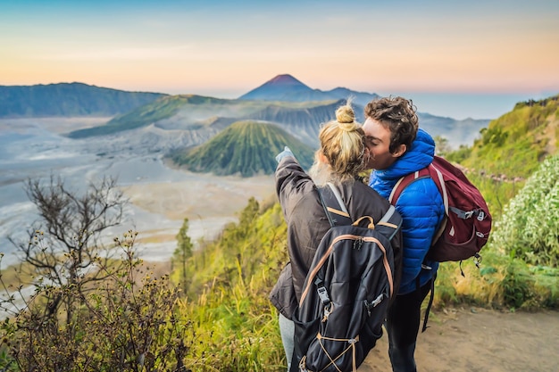 Junge paare, mann und frau treffen den sonnenaufgang im bromo tengger semeru national park auf java