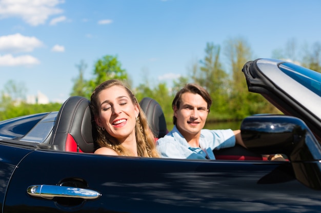 Junge Paare mit Cabriolet im Sommer auf Tagesreise