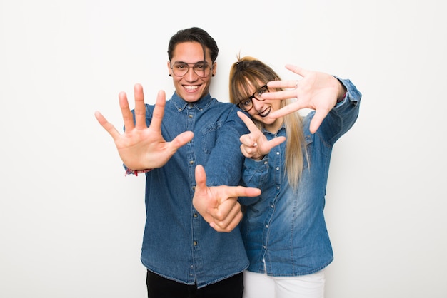 Junge Paare mit den Gläsern, die sieben mit den Fingern zählen