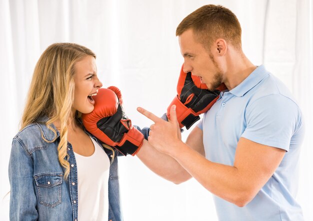 Junge Paare streiten und verwenden Boxhandschuhe.