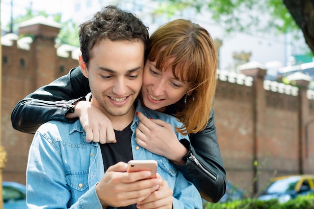 Junge Paare unter Verwendung der Anwendung auf Smartphone