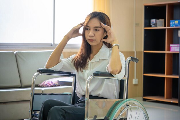 Junge Patientin mit besorgtem Gesichtsausdruck im Rollstuhl im Krankenhaus