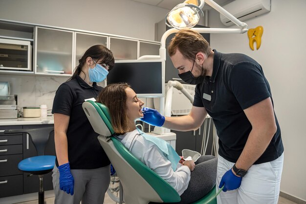 Junge Patientin sitzt in einem Zahnarztstuhl in seinem Büro Zahnheilkundebehandlung zum Bleichen der Zähne Reinheit
