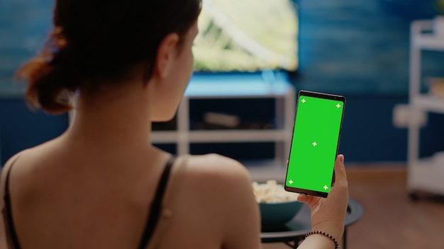 Junge Person mit vertikaler Greenscreen-Anzeige auf dem Smartphone