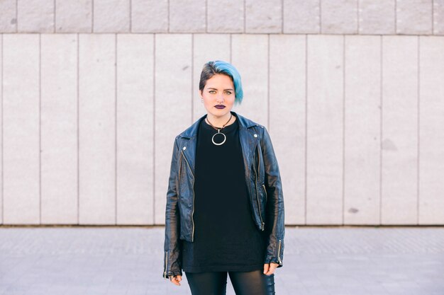 Junge Punkfrau mit blau gefärbtem Haar und einer Lederjacke