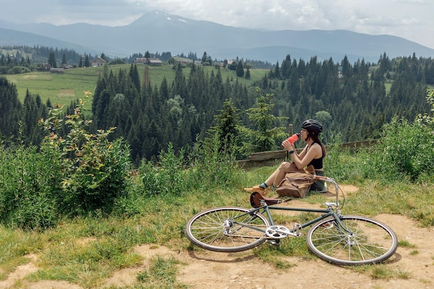 Junge Radfahrerin genießt die schöne Aussicht auf dem grünen Bergweg