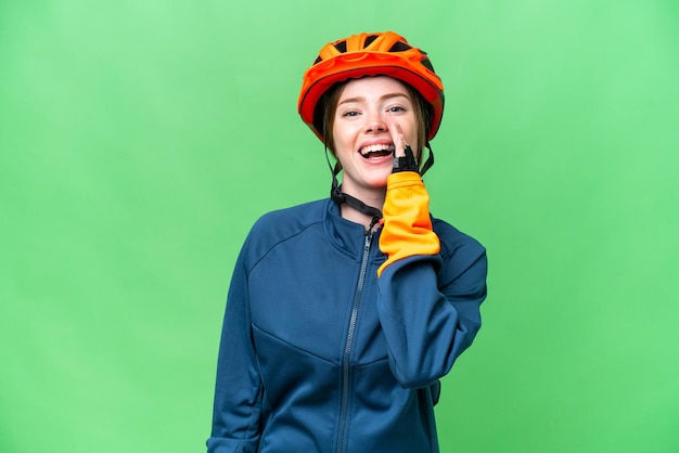Junge Radfahrerin über isoliertem Chroma-Key-Hintergrund schreit mit weit geöffnetem Mund