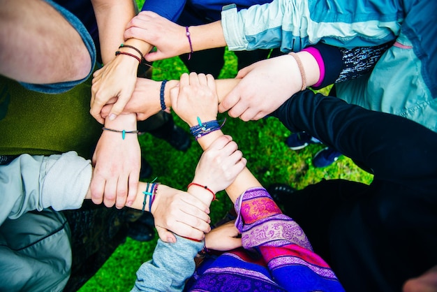 Junge Reisende, die ihre Hände zusammenlegen Freunde mit einem Stapel Hände, die Einheit und Teamarbeit zeigen