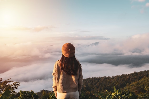 Foto junge reisende, die morgens den sonnenaufgang und das nebelmeer auf dem berg betrachten, reise-lifestyle-konzept