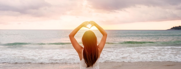 Junge Reisende, die zu Fuß gehen und den wunderschönen Sonnenuntergang am ruhigen Strand genießen. Reisen Sie im Sommerurlaubskonzept Banner-Panorama