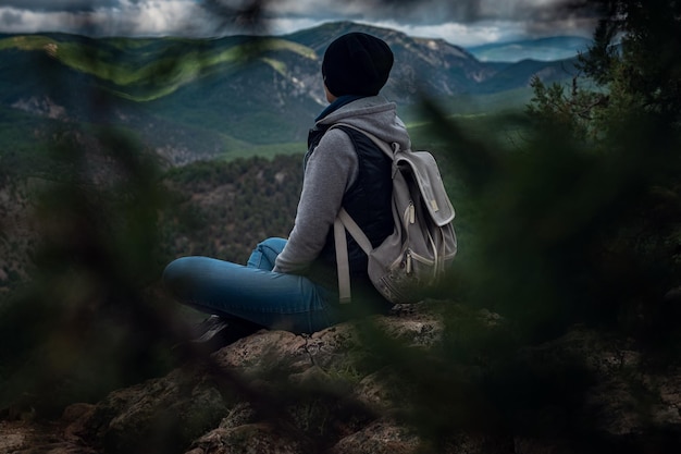 Junge reisende Frau auf der Spitze der Bergklippe