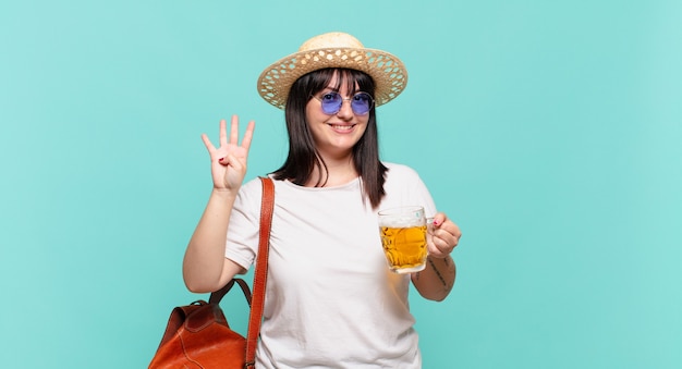 Junge reisende Frau, die lächelt und freundlich schaut, Nummer vier oder viertens mit der Hand vorwärts zeigend, herunterzählend