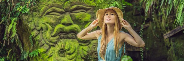 Junge reisende in einem balinesischen garten, der mit moos überwuchert ist, reisen nach bali-konzeptbanner lang