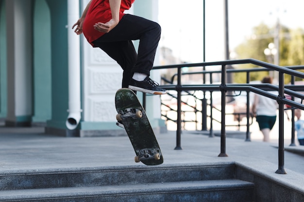 Junge Reiten Trick auf Skateboard in der Stadt.