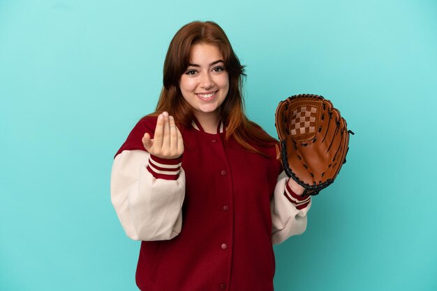 Junge rothaarige Frau, die Baseball spielt, isoliert auf blauem Hintergrund, der einlädt, mit der Hand zu kommen. Schön, dass du gekommen bist