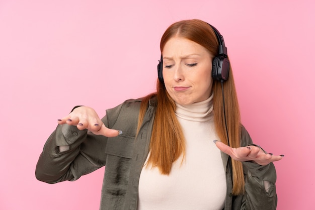 Junge rothaarige Frau, die Musik hört und tanzt