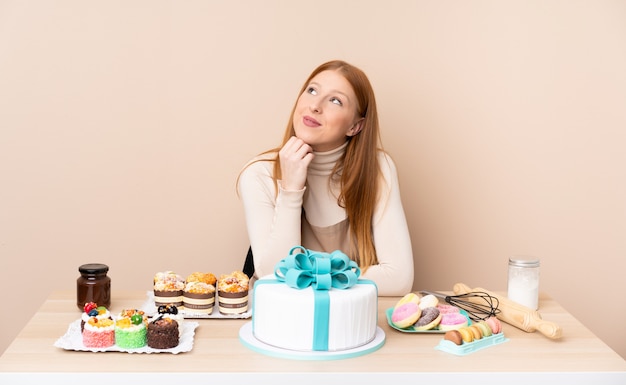 Junge rothaarige Frau mit einem großen Kuchen