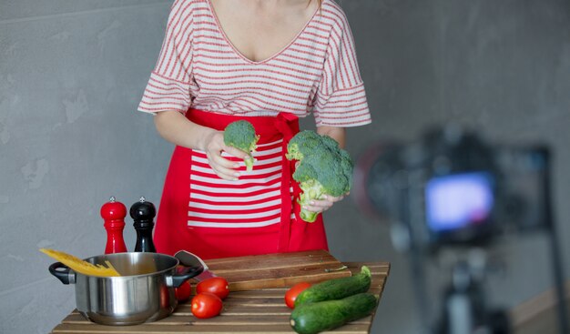 Junge Rothaarigefrau, die Video kochend macht