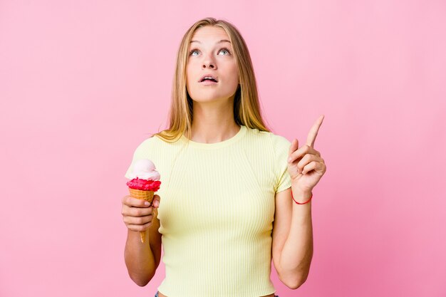 Junge russische Frau, die eine Eiscreme lokalisierte, die oben mit geöffnetem Mund zeigt.