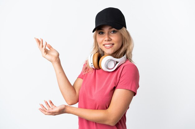 Junge russische Frau, die Musik lokalisiert auf weißem Hintergrund hört, der Hände zur Seite für die Einladung zum Kommen ausdehnt