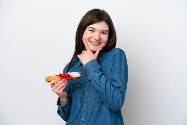 Junge russische Frau mit Sashimi isoliert auf weißem Hintergrund glücklich und lächelnd