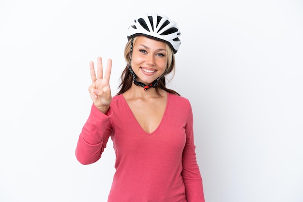 Junge russische Frau trägt einen Fahrradhelm isoliert auf weißem Hintergrund glücklich und zählt drei mit den Fingern