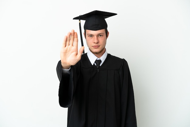 Junge russische Universitätsabsolventin isoliert auf weißem Hintergrund, die Stop-Geste macht