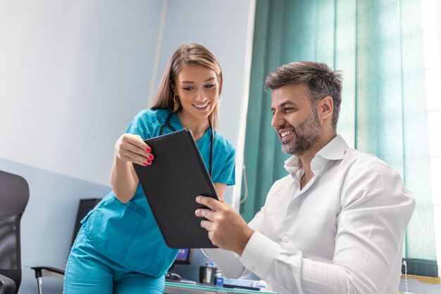 Junge Ärztin Arzt Beratung Patient im Gespräch mit erwachsenen Mann Klient bei der medizinischen Untersuchung besuchen Krankheiten Behandlung medizinisches Gesundheitskonzept