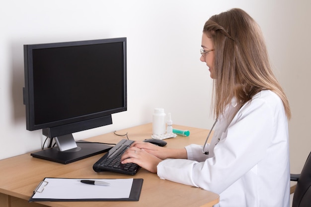 Junge Ärztin mit Computer im modernen Büro