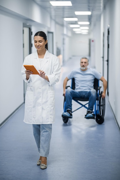 Junge Ärztin mit einem Tablet in einem Rehabilitationszentrum