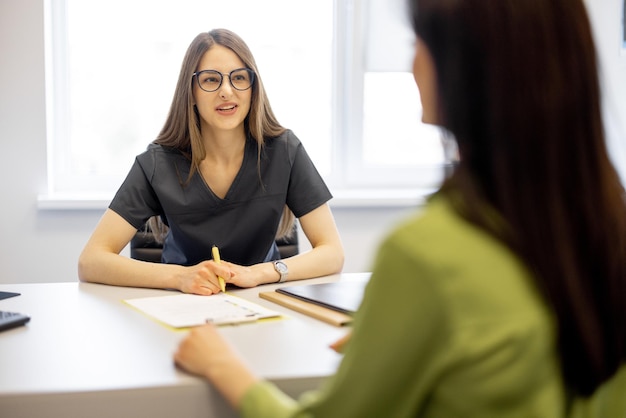 Junge Ärztin mit einer Frau im Büro