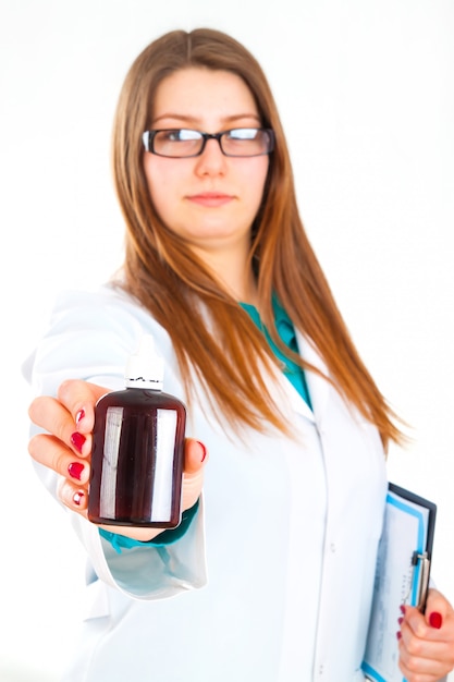 Junge Ärztin mit Pillenflasche in der Hand