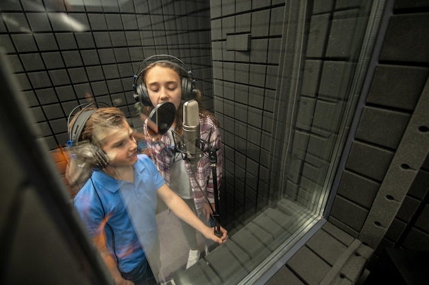 Junge Sänger singen im Tonstudio ins Mikrofon