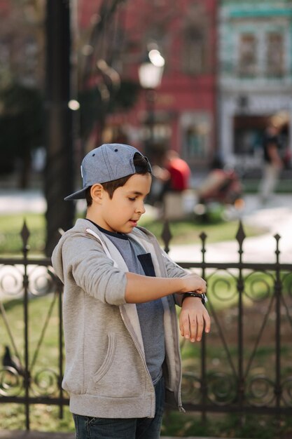 Junge schaut auf die Uhr Teenager läuft durch die Stadt