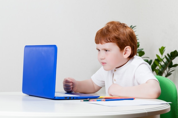 Junge schaut auf Laptop