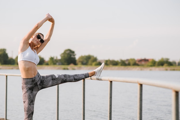 Junge, schlanke Frau, die am sonnigen Tag im Freien im Park Sport treibt