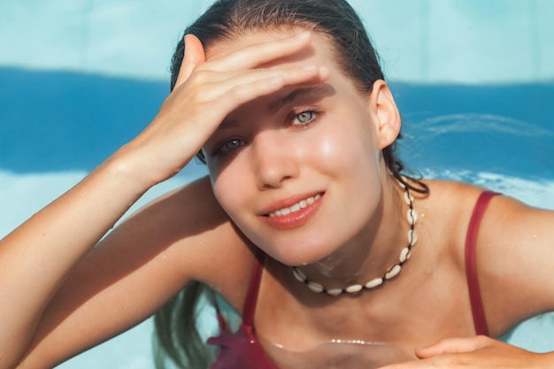 Junge schlanke Frau im Badeanzug, die sich am Swimmingpool entspannt